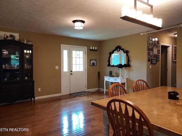 dining space with hardwood / wood-style floors and a textured ceiling