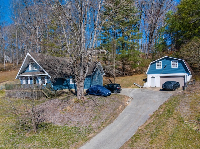 view of front of home with a garage, driveway, an outbuilding, and a gambrel roof