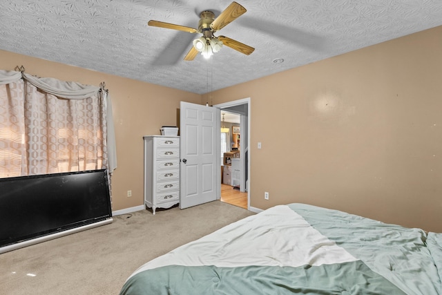 bedroom featuring light carpet, ceiling fan, a textured ceiling, and baseboards