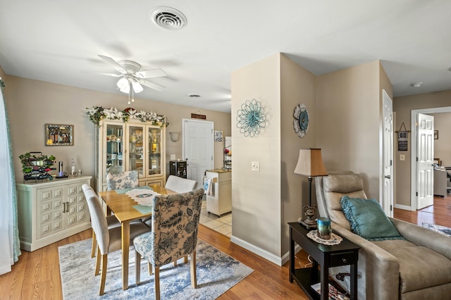 dining room with ceiling fan and light wood-type flooring