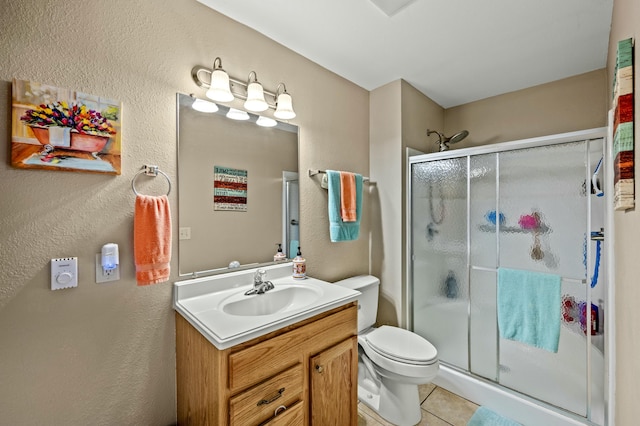 bathroom with tile patterned floors, vanity, toilet, and an enclosed shower