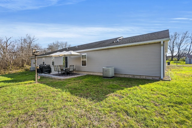 back of property with central air condition unit, a patio area, and a lawn