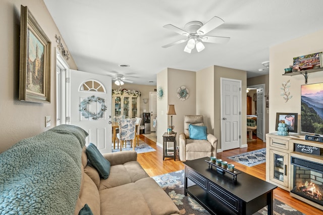 living room featuring wood-type flooring and ceiling fan