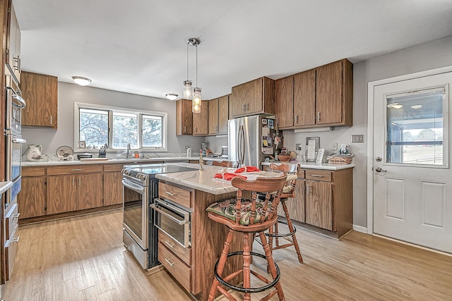 310 Par Ln, Greeneville, TN 37743 - kitchen featuring light wood-type flooring, light countertops, appliances with stainless steel finishes, and brown cabinets