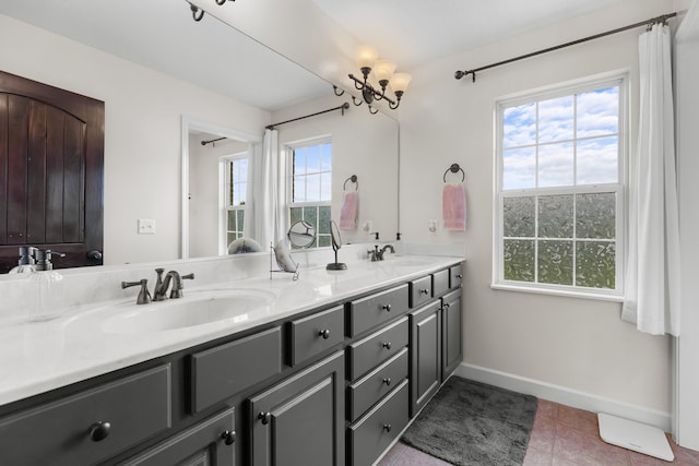 full bath with double vanity, baseboards, tile patterned flooring, and a sink