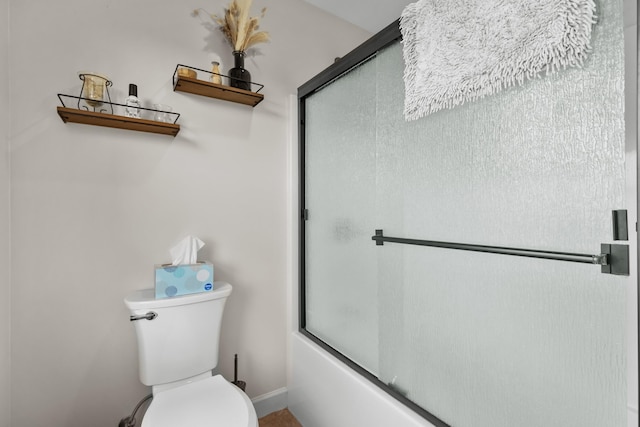 bathroom featuring toilet, baseboards, and enclosed tub / shower combo