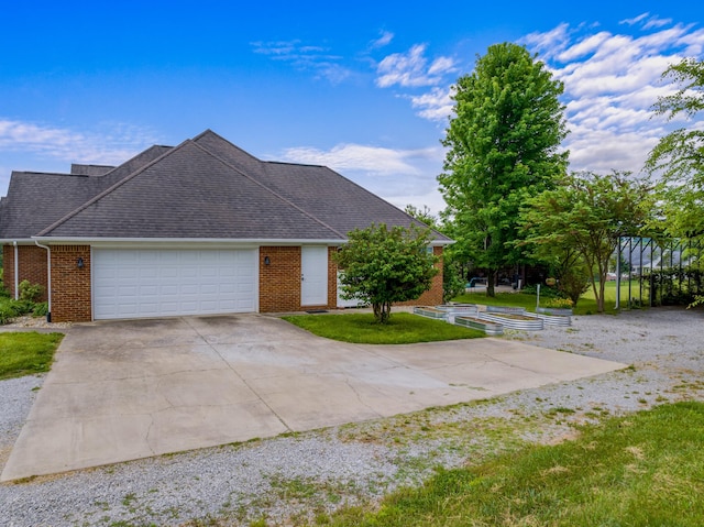 ranch-style house with an attached garage, brick siding, concrete driveway, a front yard, and a shingled roof