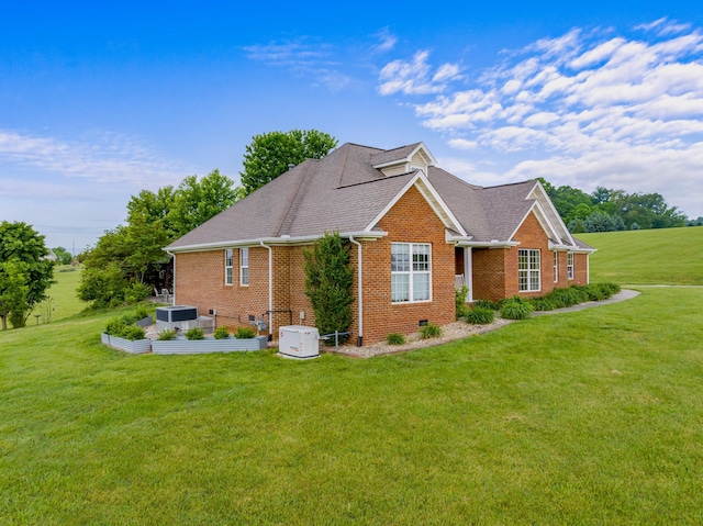 view of side of property with central air condition unit, brick siding, roof with shingles, and a lawn