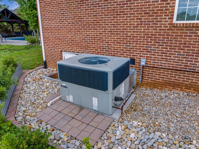 details featuring central air condition unit and brick siding