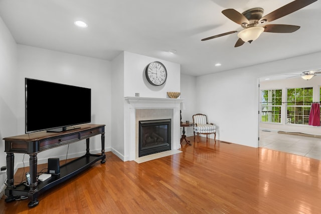 living area with wood finished floors, a ceiling fan, a fireplace, visible vents, and recessed lighting