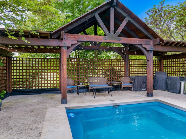view of pool featuring a gazebo, a patio area, a fenced in pool, and grilling area