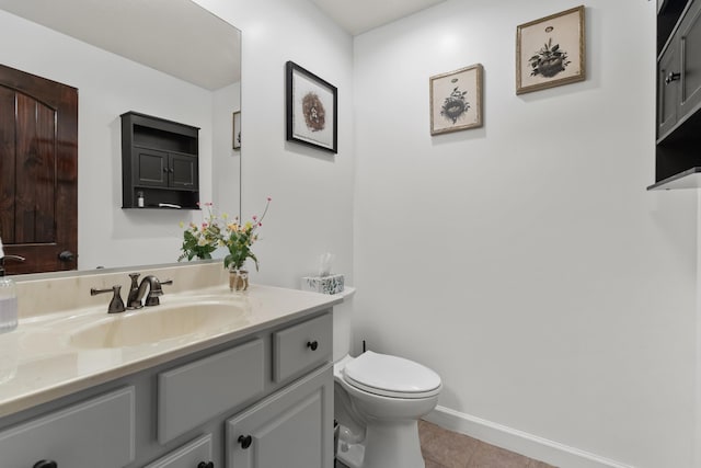 half bath featuring tile patterned flooring, toilet, baseboards, and vanity