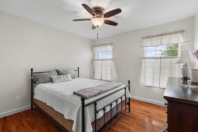 bedroom featuring ceiling fan, baseboards, and light wood-style floors