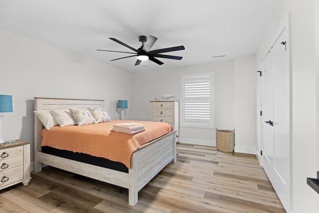 bedroom featuring light wood-type flooring, a closet, and ceiling fan