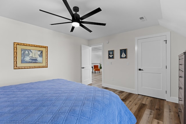 bedroom with ceiling fan, wood-type flooring, and vaulted ceiling