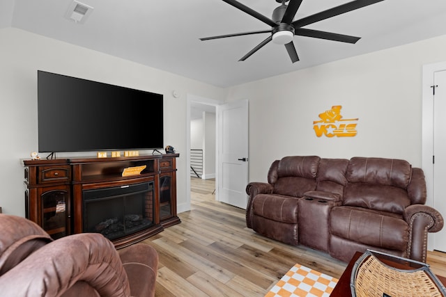 living room featuring ceiling fan and light hardwood / wood-style floors