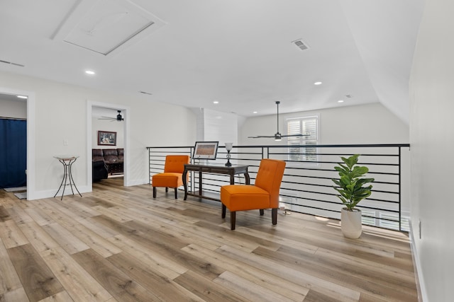 living area with ceiling fan, light hardwood / wood-style flooring, and lofted ceiling