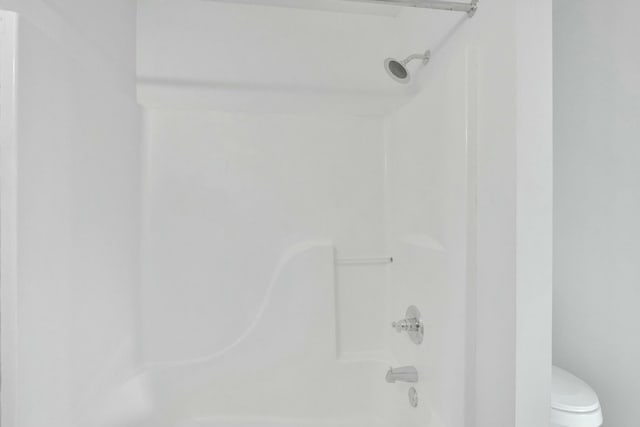 bathroom with toilet and bathing tub / shower combination