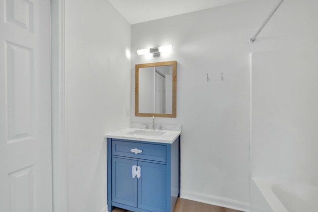 bathroom featuring baseboards, vanity, and wood finished floors