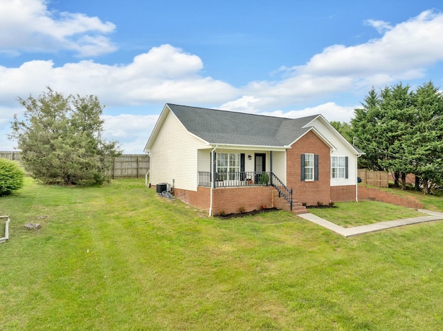 view of side of property featuring brick siding, a yard, a porch, and fence
