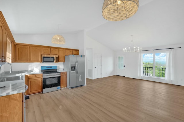 kitchen featuring light countertops, a sink, light wood-style floors, appliances with stainless steel finishes, and a notable chandelier