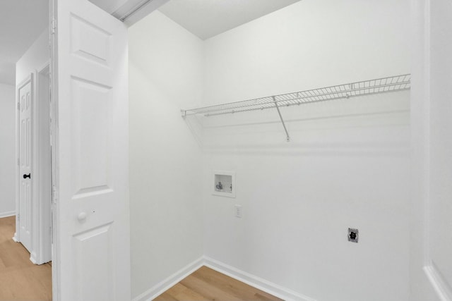 washroom with hookup for an electric dryer, light wood-style flooring, baseboards, laundry area, and washer hookup