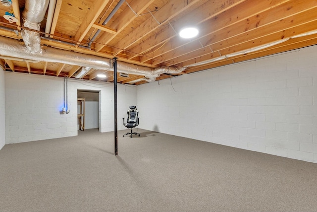 basement featuring carpet flooring and concrete block wall