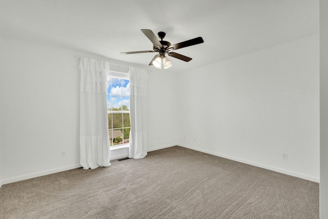 carpeted empty room with visible vents, a ceiling fan, and baseboards