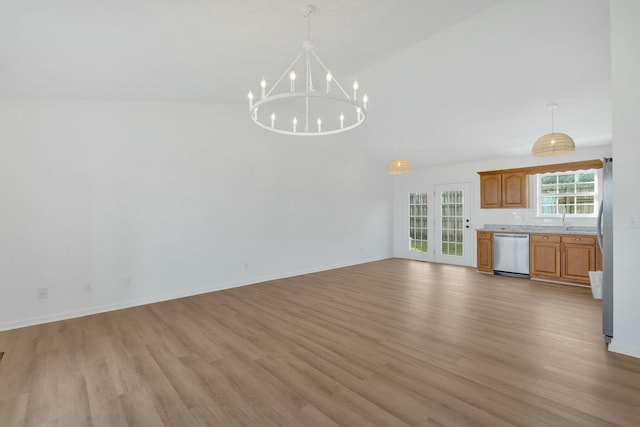 unfurnished living room with a sink, baseboards, an inviting chandelier, light wood-style floors, and high vaulted ceiling