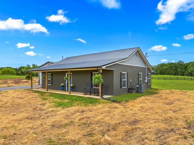 rear view of property with central AC, a patio, and metal roof