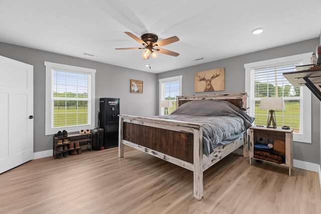 bedroom with baseboards, multiple windows, light wood-style floors, and recessed lighting