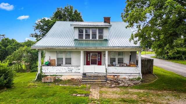 323 Pauline Ave, Morristown, TN 37813 - view of front facade with a chimney, a porch, metal roof, and a front lawn