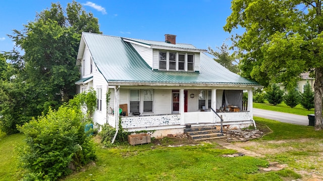 323 Pauline Ave, Morristown, TN 37813 - view of front facade featuring a porch, a chimney, metal roof, and a front lawn