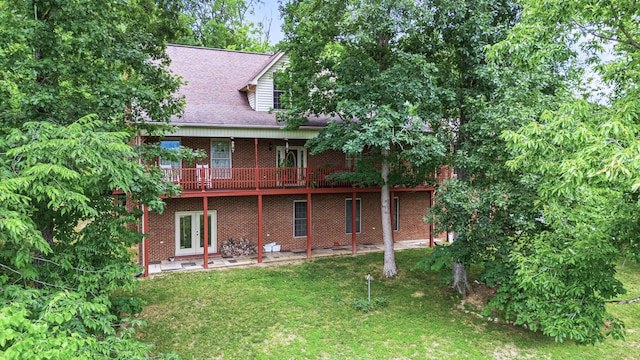 back of house featuring a wooden deck and a lawn