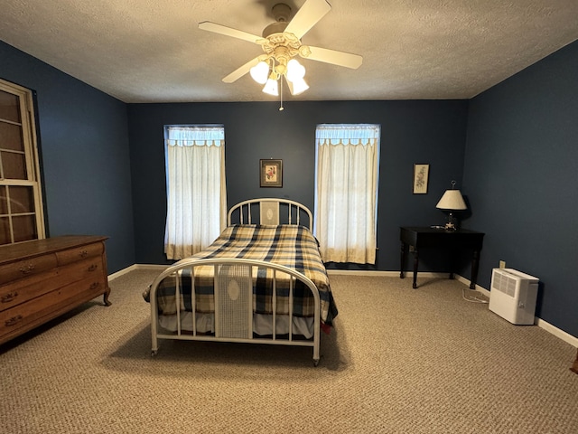 carpeted bedroom with ceiling fan and a textured ceiling