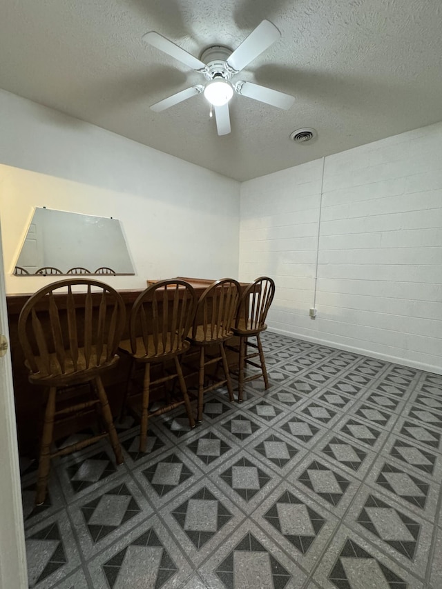 dining space with a textured ceiling and ceiling fan