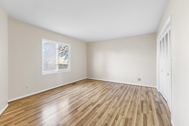 unfurnished bedroom featuring light wood-type flooring and a closet