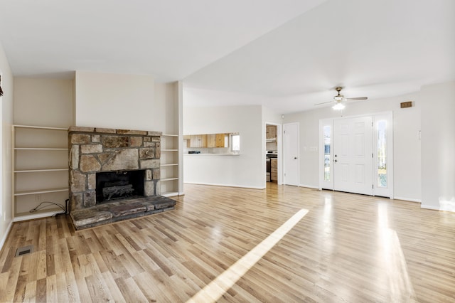 unfurnished living room with a fireplace, ceiling fan, and light wood-type flooring