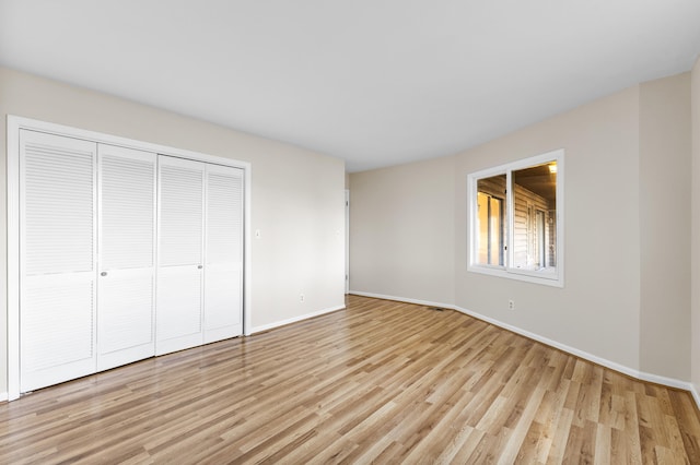 unfurnished bedroom with light hardwood / wood-style floors and a closet