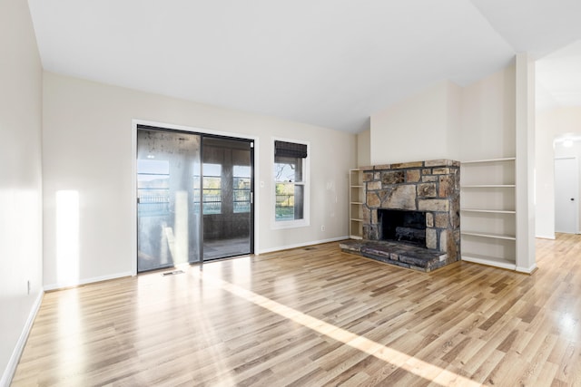 unfurnished living room with light hardwood / wood-style flooring, a fireplace, and vaulted ceiling