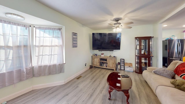 living room featuring light hardwood / wood-style floors and ceiling fan