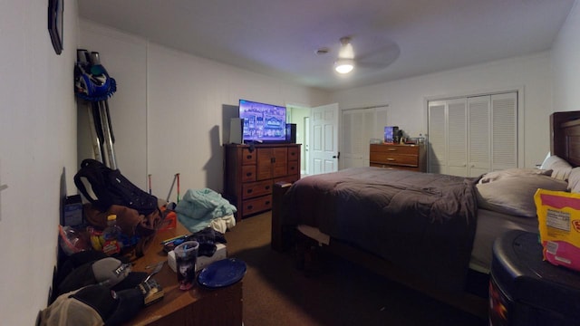 carpeted bedroom with ceiling fan and multiple closets