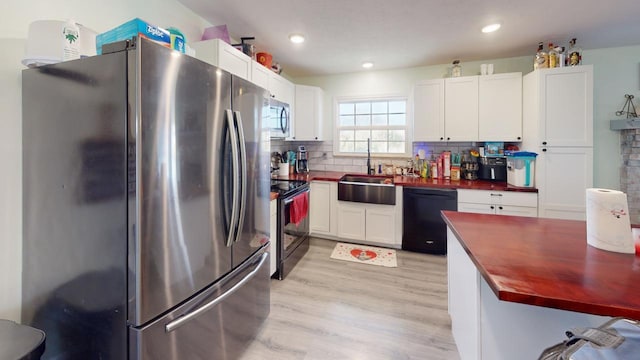 kitchen featuring butcher block counters, tasteful backsplash, stainless steel appliances, and white cabinets