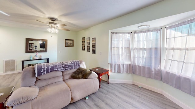 living room with ceiling fan and light wood-type flooring