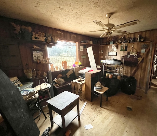 miscellaneous room with ceiling fan and wooden walls