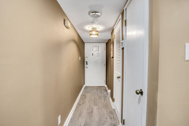 doorway to outside with light wood-type flooring and baseboards