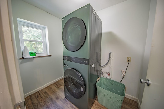 laundry area featuring stacked washer and dryer and dark hardwood / wood-style floors