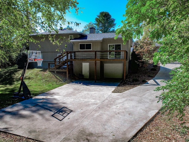 view of front facade featuring a deck, a front yard, and a garage