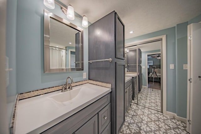 bathroom featuring tile patterned flooring, vanity, and a textured ceiling