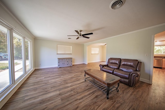 living room with dark hardwood / wood-style flooring, ceiling fan, and ornamental molding